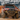 Low angle slightly quartering view of a maroon 4Runner offroading in the mountains and equipped with a C4 Overland bumper.